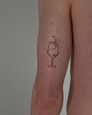 Fine line tattoo by Faith Llewellyn featuring a delicate design of a glass and drink, perfect for those who appreciate refined art.