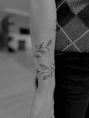 Experience the delicate beauty of Ruth Hall's fine line floral design, crafted with precision and elegance. Perfect for those seeking a subtle yet stunning tattoo.