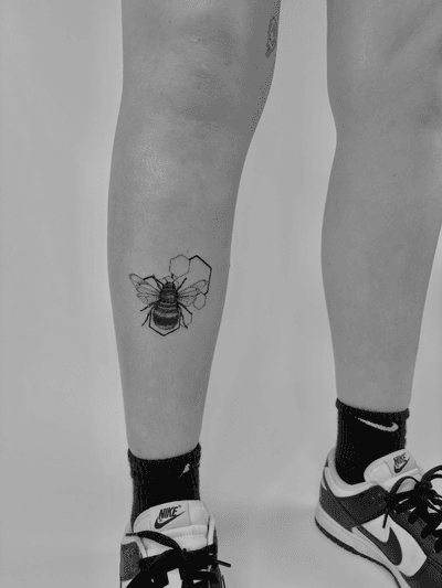 Experience the intricate fusion of geometric and micro_realism styles in this stunning bee tattoo by the talented artist Ruth Hall.
