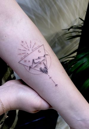 Experience the beauty of nature with this fine line and illustrative tattoo featuring a striking mountain landscape. Created by talented artist Ruth Hall.