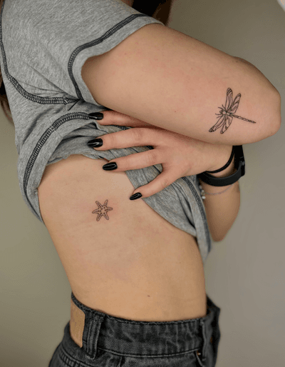 Elegant and intricate tattoo by Ruth Hall featuring a delicate dragonfly and starfish design in fine line style.
