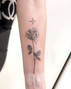 Experience the artistry of Bradley Mollett in this stunning black & gray rose tattoo. Embrace the beauty of a delicate flower in a hyper-realistic style.