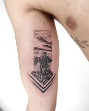 A stunning black-and-gray illustrative tattoo of a mountain scene with an intrepid explorer, created by Bradley Mollett.