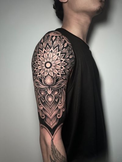 Experience the harmonious blend of geometric shapes and intricate mandala design with this stunning tattoo created by Avi.