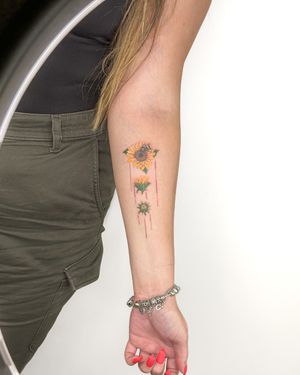 Experience the beauty of a lifelike sunflower in vivid colors with this stunning micro-realism tattoo by artist Bradley Mollett.