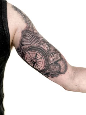 Admire Bradley Mollett's stunning black and gray tattoo featuring intricate compass and fern motifs. A true masterpiece of realism and artistry.