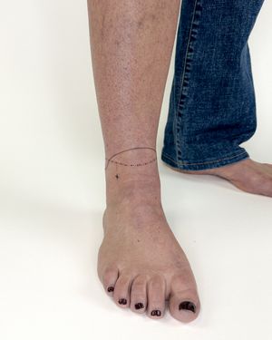 Elegantly designed fine line ankle tattoo by Bradley Mollett, perfect for those seeking a delicate and subtle touch of ink.