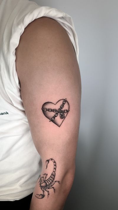 An illustrative black and gray tattoo of a heart, lock, and chain by artist Joshua Williams. Symbolizing love and commitment.