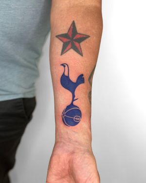 Get inked with this illustrative tattoo of the iconic Tottenham Hotspur logo by artist Bradley Mollett.