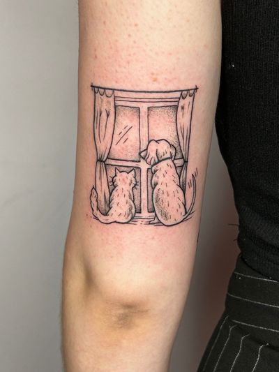Illustrative tattoo by Jonathan Glick featuring a dog and cat looking out a window, capturing the essence of beloved pets.