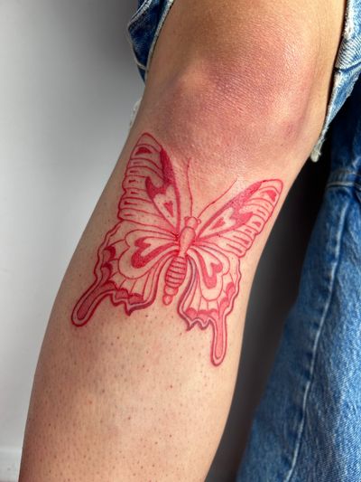 Get mesmerized by Jonathan Glick's illustrative butterfly design in striking red ink. Embrace the beauty of nature with this stunning tattoo!