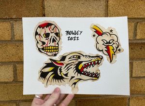 Traditional colour flash featuring a wolf head, skull and cloud with a lightning bolt 