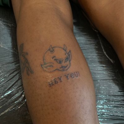 Get a traditional small lettering tattoo of a devil by the talented artist Julia Bertholdi. Perfect for those looking for a subtle yet edgy design.