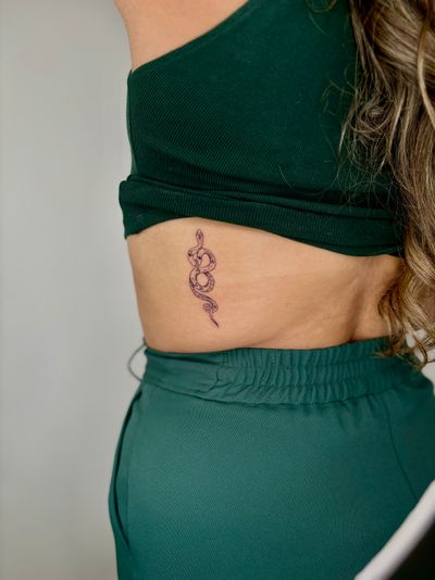 Embrace the mystical allure of a fine line illustrative snake tattoo by the talented Ruth Hall. Let the serpentine beauty slither onto your skin.