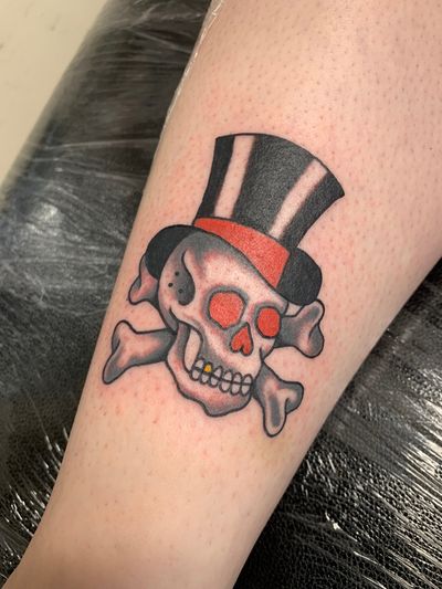 Get inked with this classic skull and top hat design by Laurel, perfect for those who love traditional tattoos.