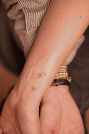 Experience the beauty of hand-poked fine line art with this delicate star tattoo crafted by the talented artist Anna.