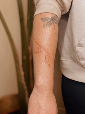 Embrace the beauty of nature with this fine line hand poke tattoo by tattoo artist Anna. Intricate design of delicate leaves and vines.