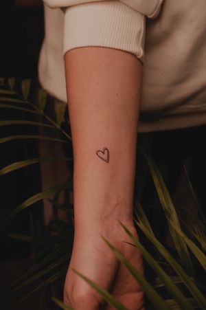 Embrace love with this fine line hand-poke heart tattoo by Anna, perfect for those looking for a subtle yet elegant design.