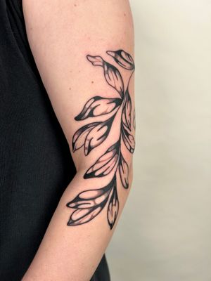 Elegant vine motif tattoo in bold blackwork style, expertly crafted by the talented artist Jack Howard.