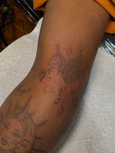 Beautiful illustrative unicorn tattoo on dark skin by Julia Bertholdi, expert in fine line tattoos.