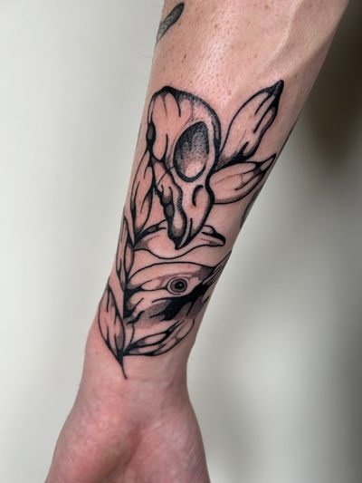 Elegant blackwork tattoo featuring a bird and skull motif, expertly crafted by renowned artist Jack Howard.
