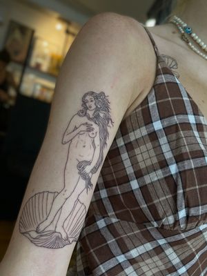 Delicate and detailed illustrative tattoo capturing the timeless beauty of the birth of Venus, created by talented artist Julia Bertholdi.