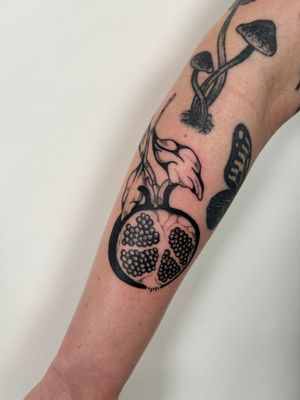 Experience Jack Howard's mastery in dotwork creating a stunning blend of flower and pomegranate in striking blackwork design.