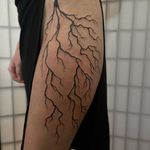 Electrify your skin with this bold blackwork lightning tattoo by the talented artist Julia Bertholdi. A powerful statement piece for those who embrace the power of nature.