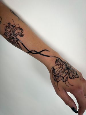 Get a stunning blackwork spider lily tattoo done by the talented artist Jack Howard. Embrace the dark beauty of this unique floral design.