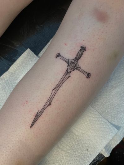 Julia Bertholdi's detailed illustrative tattoo featuring a striking sword motif.