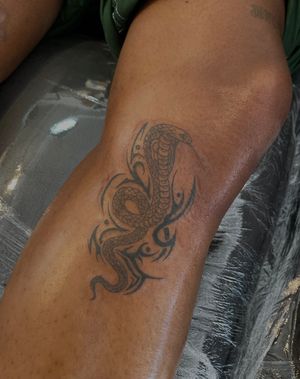 Experience the power of the snake in this stunning illustrative tribal tattoo on dark skin by Julia Bertholdi.