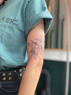 Get a stunning illustrative tattoo of a lemon branch with fine line detail by the talented artist Julia Bertholdi.