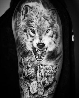  a wolf accompanied by two adorable baby wolves tattoo