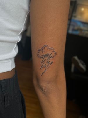 Experience the power of nature with this striking tattoo featuring storm clouds and lightning, beautifully executed by artist Julia Bertholdi.