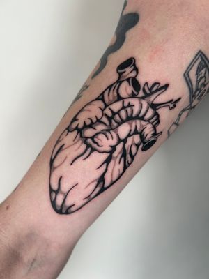 This stunning blackwork heart tattoo by Jack Howard combines bold lines with intricate details for a truly striking design.