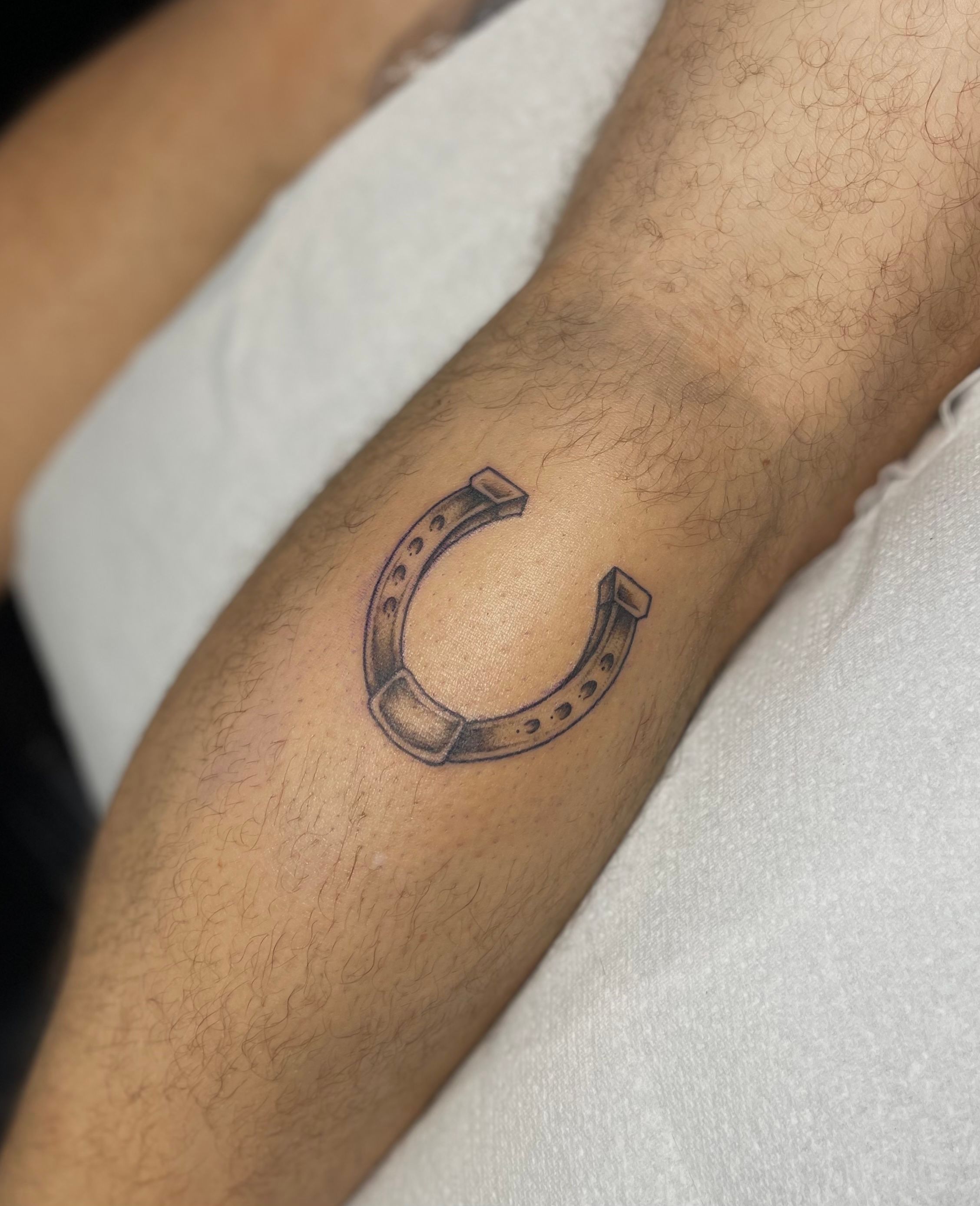 Minimal horseshoe tattoo inked on the left forearm | Horse shoe tattoo,  Hand tattoos, Finger tattoos