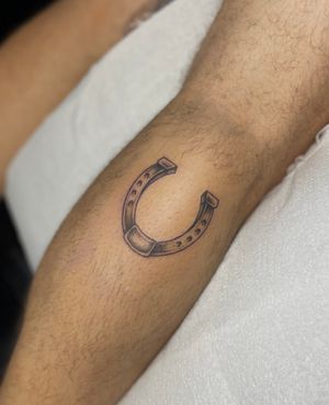 Capture good luck with this intricate illustrative horseshoe tattoo by talented artist Julia Bertholdi. Perfect for those seeking unique and meaningful body art.