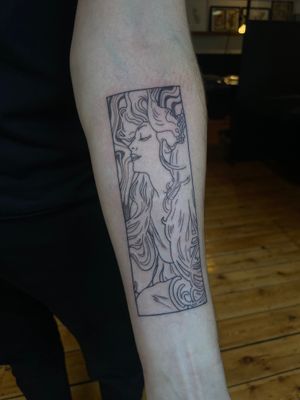 Experience the beauty of Alphonse Mucha's style through the skilled hands of Julia Bertholdi in this stunning illustrative tattoo.