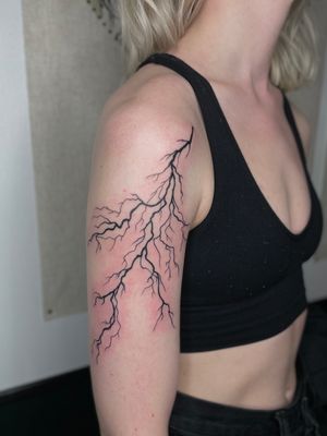 Intricate blackwork design of lightning bolts by Julia Bertholdi, adding a striking and energetic element to your body art.