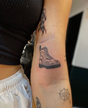 Get a unique blackwork tattoo by Julia Bertholdi featuring a detailed boot and sneaker design.