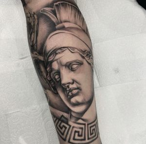 Elegant black and gray illustrative tattoo of a statue, expertly designed by Sam Waiting.