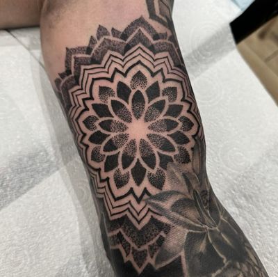 Blackwork and dotwork tattoo by Sam Waiting, featuring a detailed mandala design.