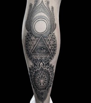 All seeing eye in sacred patterns on lower leg 
