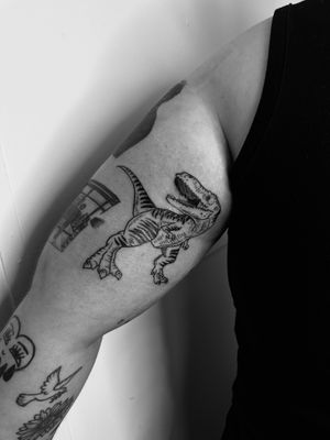 Embrace your inner dinosaur with this fierce and detailed blackwork tattoo by the talented Oliver Soames.