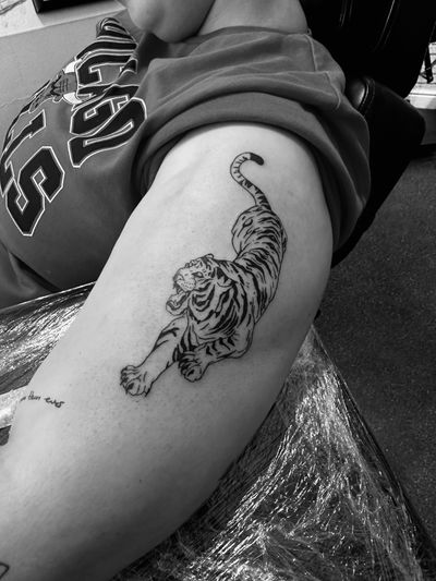 Roar with this fierce and detailed illustrative tiger tattoo by the talented artist Oliver Soames. Show off your wild side with this stunning design.