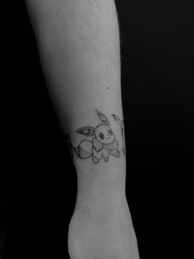 Get a unique anime style tattoo of Pokemon's Eevie done by the talented artist Oliver Soames for a playful and colorful design.