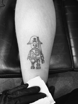 Sail the high seas with this unique pirate Lego tattoo by artist Oliver Soames. Perfect for any Lego or pirate enthusiast!