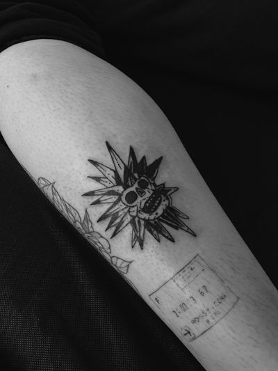 Bold blackwork tattoo featuring a detailed sun and skull motif, expertly done by tattoo artist Oliver Soames.