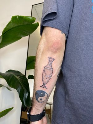 Illustrative design by Charlie Macarthur, this elegant tattoo features a detailed vase in stunning black and gray tones.