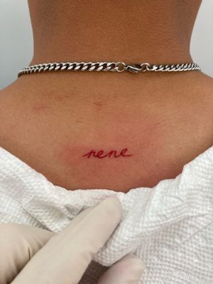 Elegant small lettering tattoo by Ronny East, revealing hidden messages in a delicate and mysterious way.